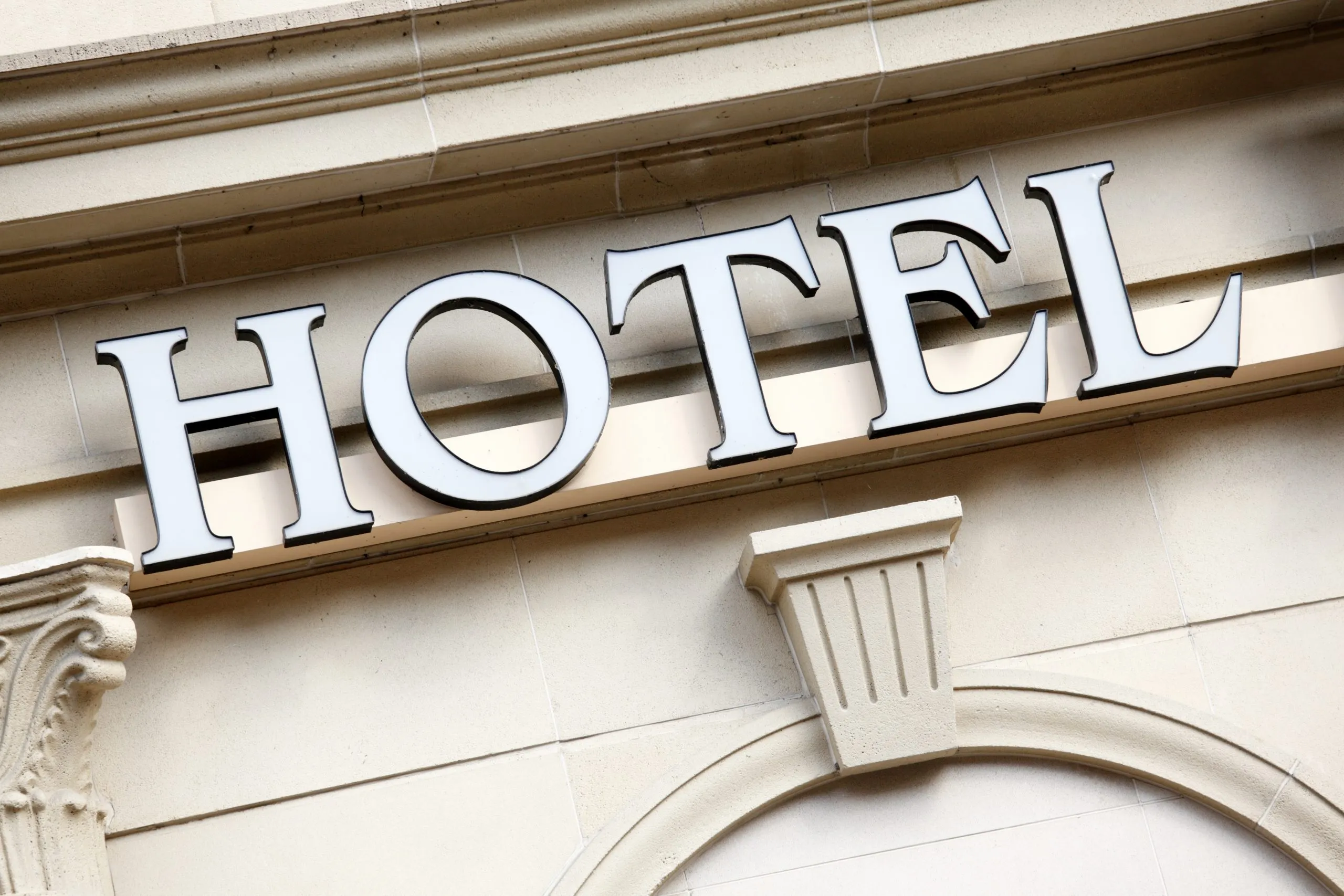 Entrada elegante de un hotel moderno, reflejando la recuperación y gestión hotelera post-pandemia con un diseño vanguardista y acogedor.