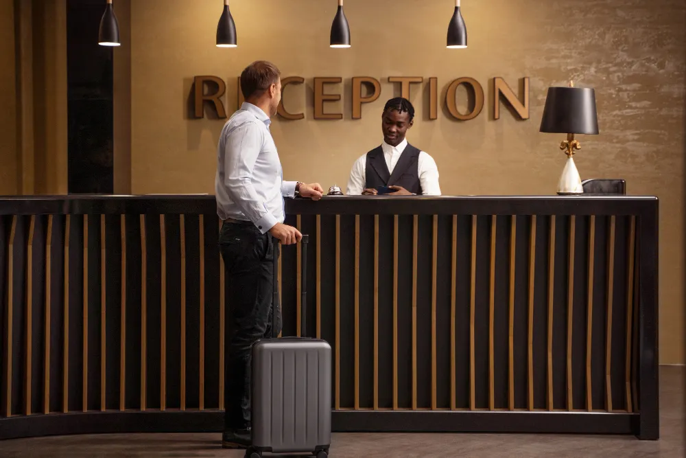 Profesional utiliza un motor de reservas online en su tablet para gestionar reservas hoteleras de forma eficiente.