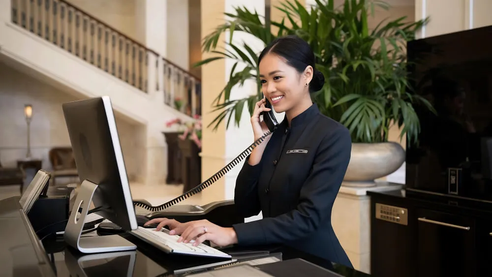 Profesional hotelero gestionando reservas en un software PMS para optimizar operaciones y la experiencia del cliente.