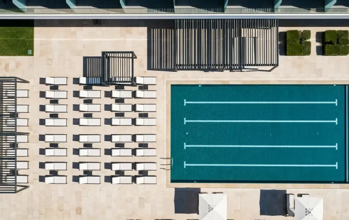 Piscina de lujo en hotel moderno con terraza, reflejando la transformación digital en la experiencia del huésped y eficiencia operativa.